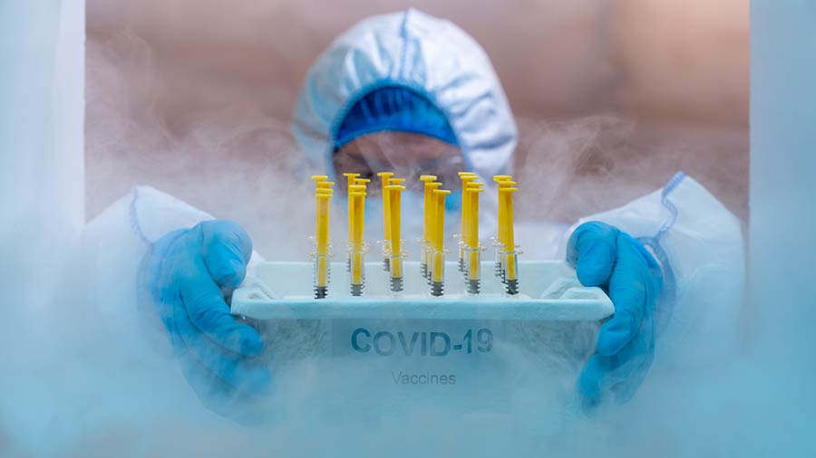 A specialist retrieving COVID vaccines from a freezer